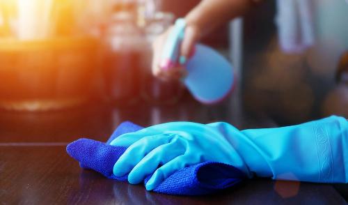 A close up of hands in rubber gloves cleaning