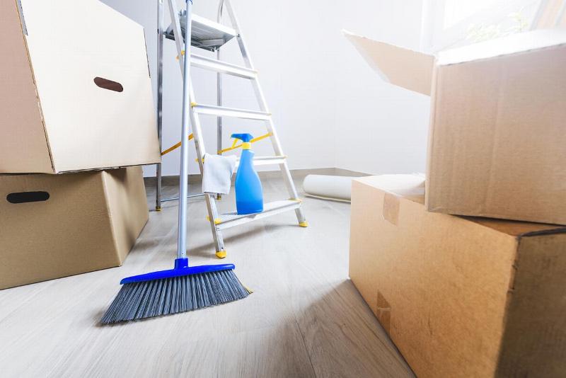 A broom propped up by moving boxes